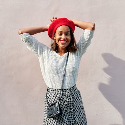 Young woman wearing a red beret and smiling, thinking about how January 24, 2022 will be the best we...