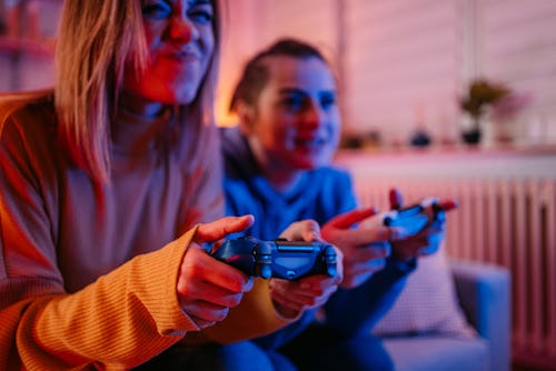 The best video games to play with friends being played by two women on the couch.