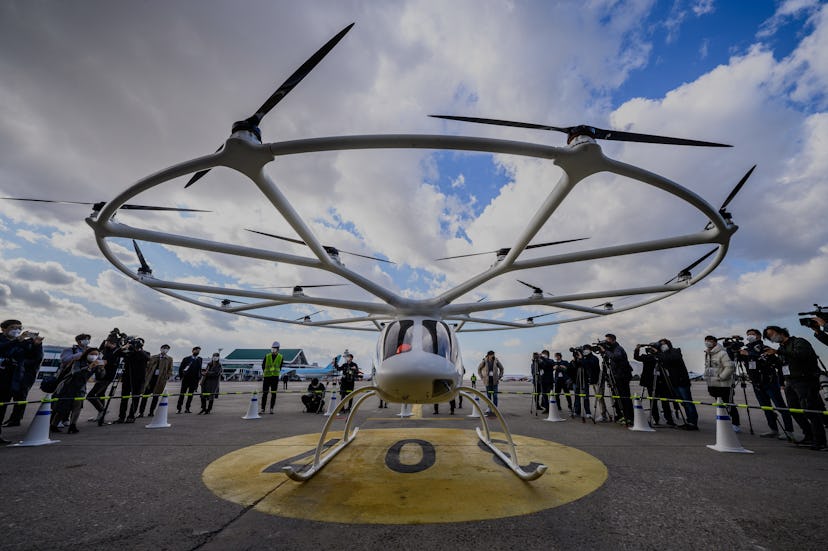 Members of the media stand near Germany-based company Volocopter 2X's air taxi after it was used for...