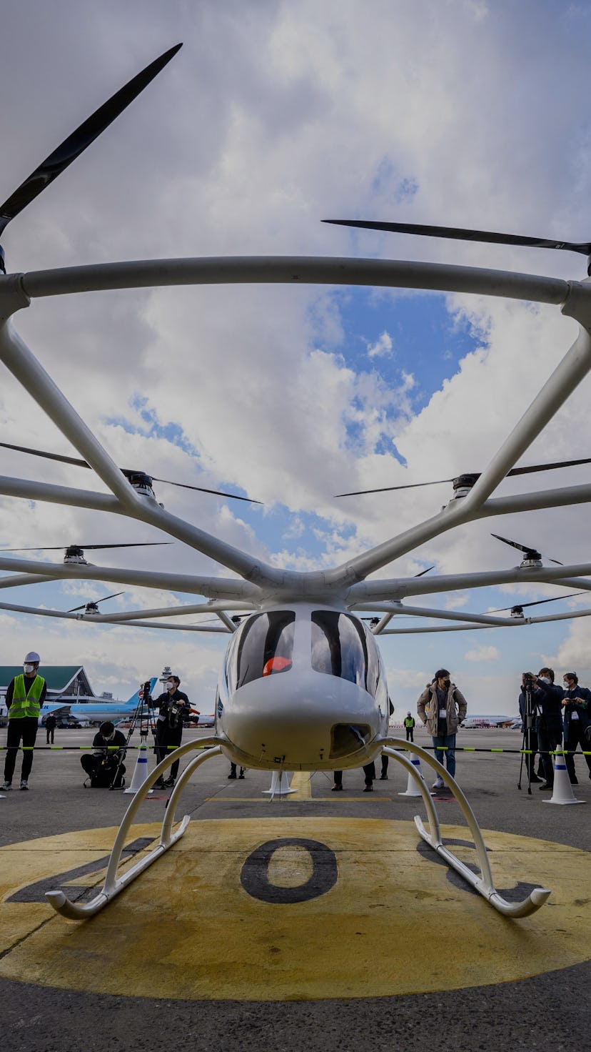 Members of the media stand near Germany-based company Volocopter 2X's air taxi after it was used for...