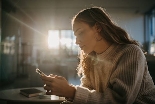 One young woman using smart phone at home to block someone on Instagram for privacy.