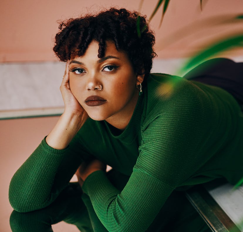 Young woman lounging on the floor, thinking about how her unlucky zodiac sign will have the worst we...