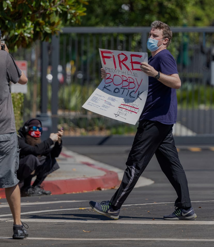 A man carrying a sign accusing Activision Blizzard CEO Robert A. Kotick of pedophilia is ordered by ...