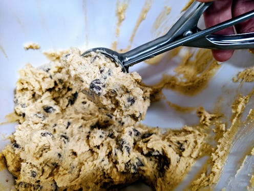 Scooping raw chocolate chip cookie dough
