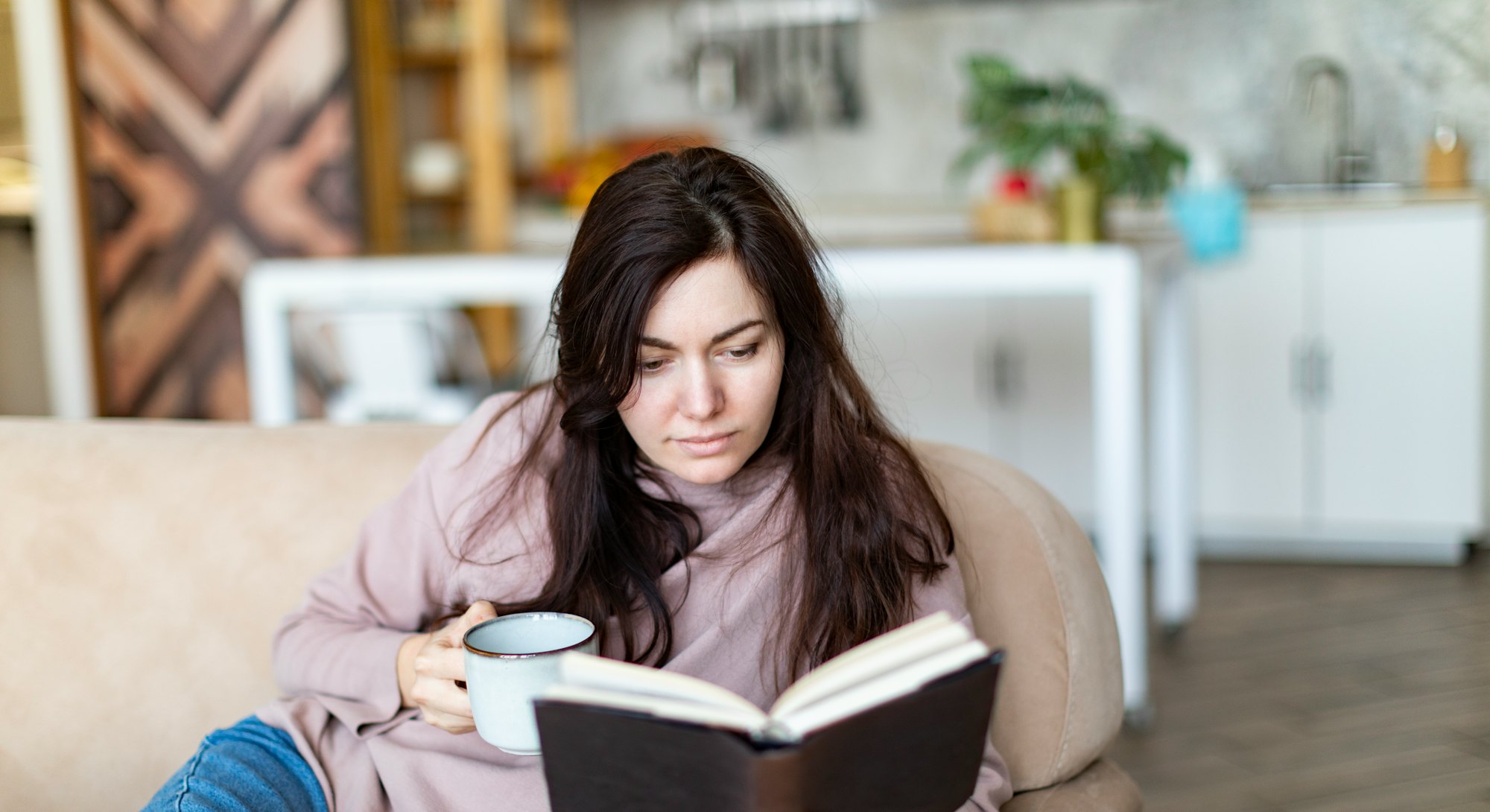 Young woman resting at home reading book