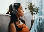 Shot of a young woman using headphones while relaxing on the sofa at home