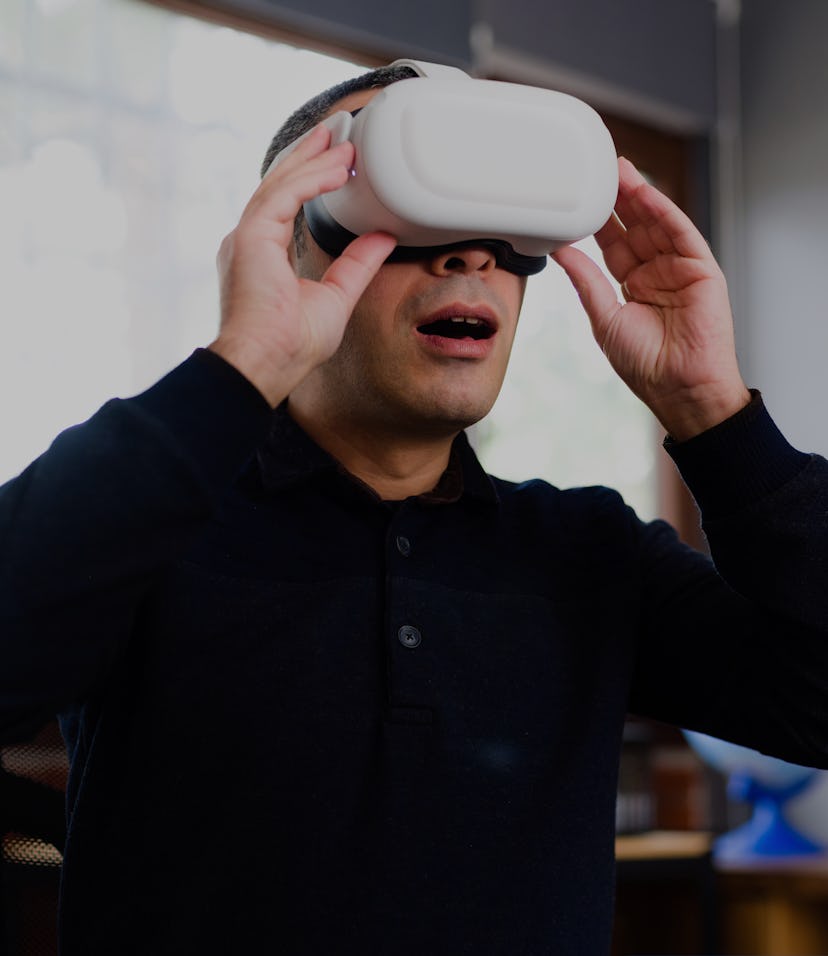 Businessman Wearing VR Headset Running A Business Meeting At Home