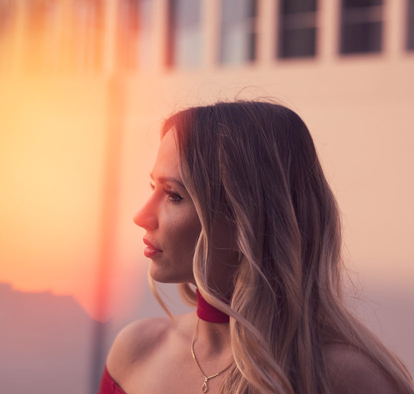 Young woman looking toward the sunlight, thinking about the fact that February 2022 will be the wors...