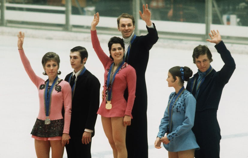 Irina Rodnina and Alexei Ulanov (C) from the Soviet Union smile as they wave to the crowd on the pod...