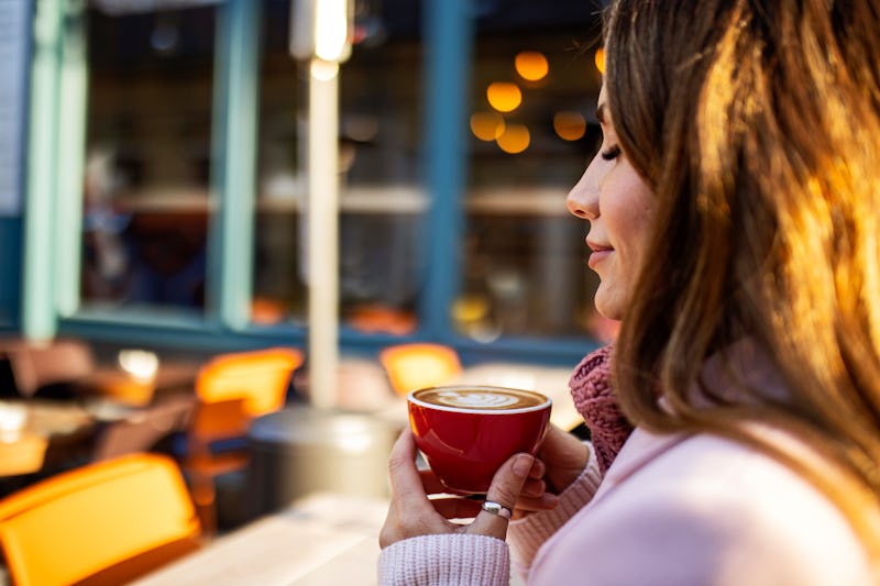 Smiling young woman drinking coffee