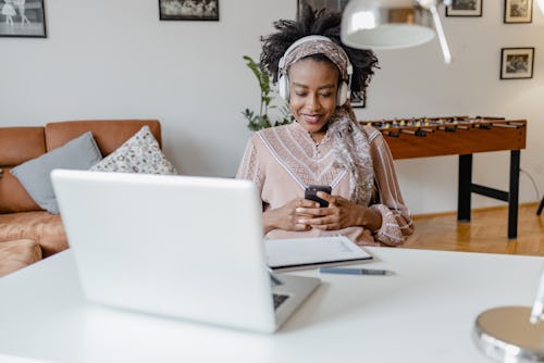 A woman working looks at productivity apps on her phone.