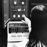 A woman adjusting an Applied Logic Corporation (AL/COM) time sharing AL-10 computer system, which co...