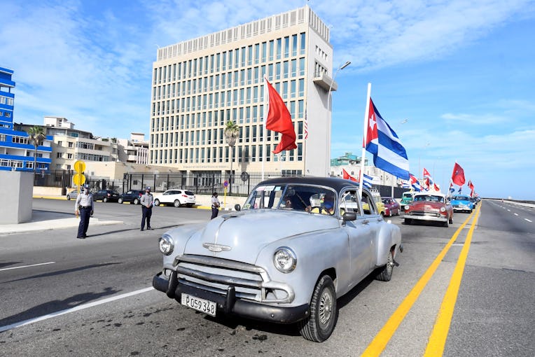 People participating in a rally against U.S. embargo pass by the U.S. embassy in Havana, Cuba, Aug. ...