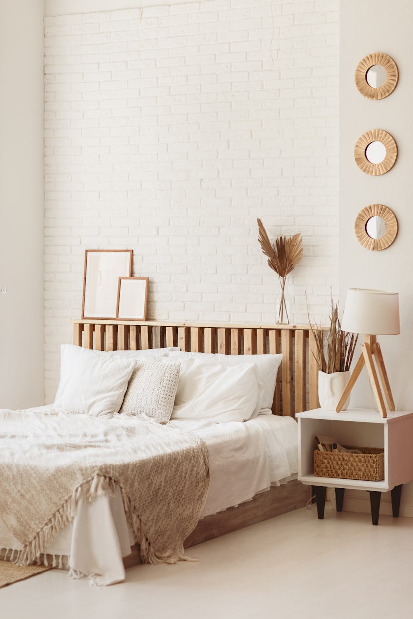 Light and spacious bedroom with white wall and eco DIY wooden furniture. Cozy bright bedroom in rust...
