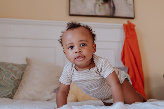 black kid on the bed looking at the camera