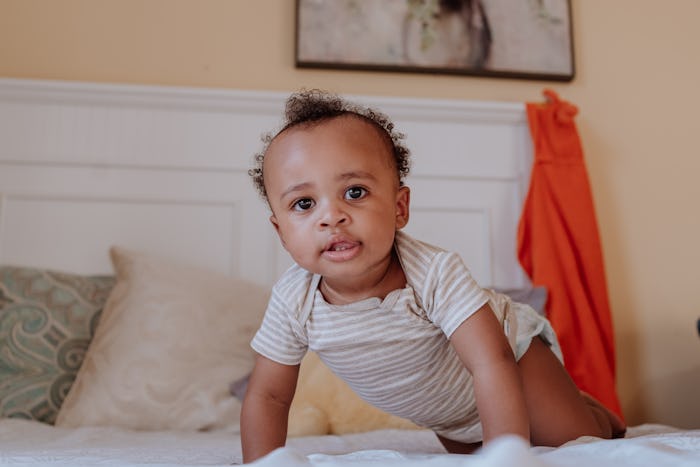 black kid on the bed looking at the camera