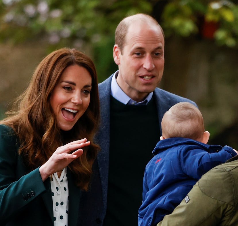 Kate Middleton and Prince William look excitedly at a baby.