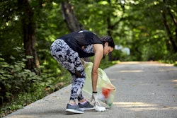 A woman picks up litter while jogging. The plogging trend on TikTok, explained.