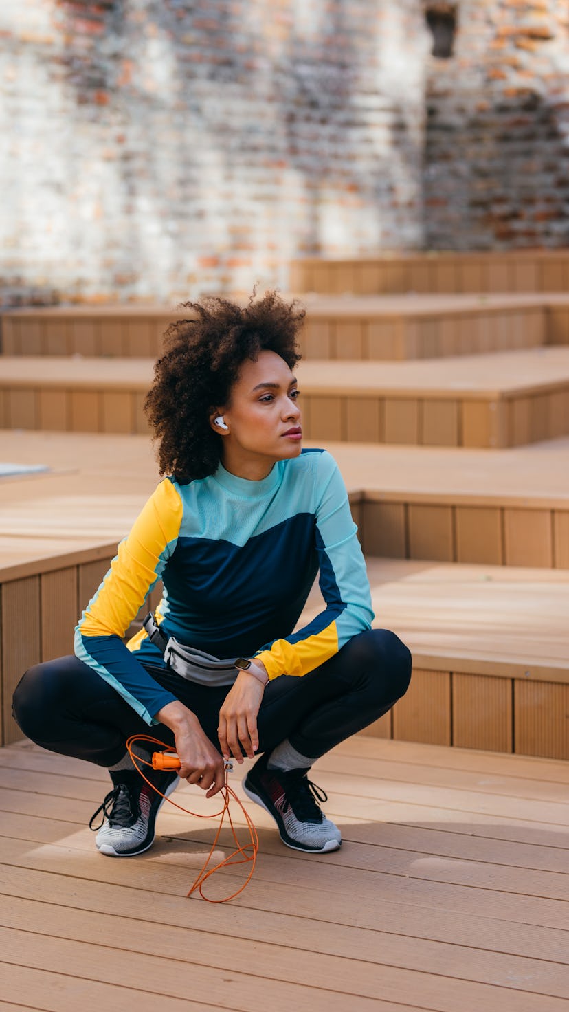 A woman takes a break while jumping ropes, one of the best high-energy workouts.