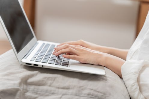 Close-up unrecognizable woman using laptop while working from home. female hands typing on the lapto...