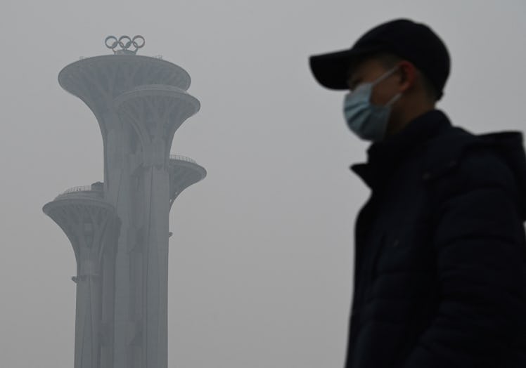 TOPSHOT - A man walks in the Olympic Park during a smoggy day in Beijing on January 24, 2022. (Photo...