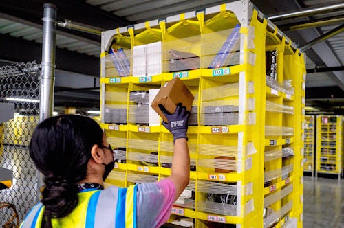 EASTVALE, CA - AUGUST 31: Worker Melissa Navarrete Urena stows goods into a movable pallet at Amazon...