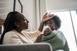 Mother checking temperature of daughter using nebulizer during inhalation therapy