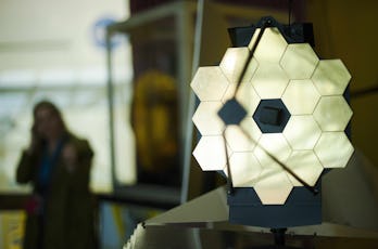 A woman stands near a model of the James Webb Space Telescope (JWST) at NASA Goddard Space Flight Ce...