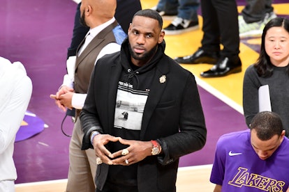 LeBron James wearing a blazer and hooded sweatshirt during a basketball game between the Los Angeles...