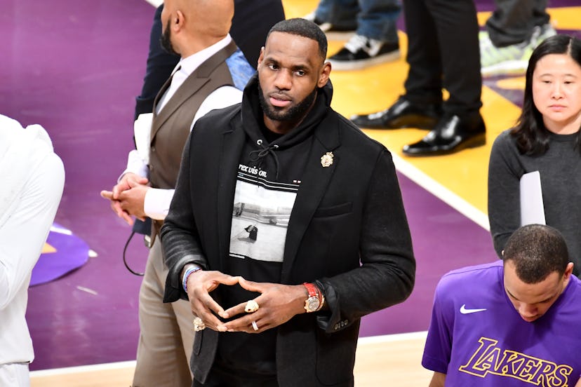 LeBron James wearing a blazer and hooded sweatshirt during a basketball game between the Los Angeles...