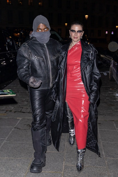 Kanye West in all black and Julia Fox in a red dress and black trench are seen in Paris. 