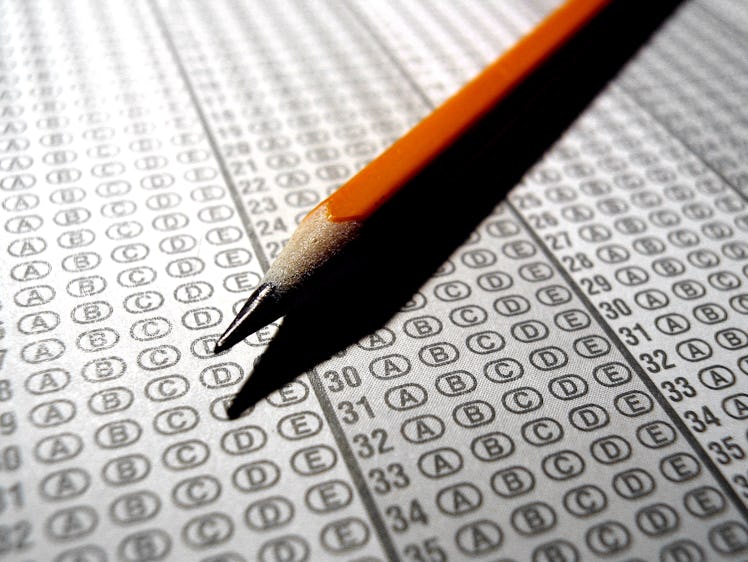 A close up of an optical scan exam answer sheet and a pencil. The answer sheet was desaturated of co...