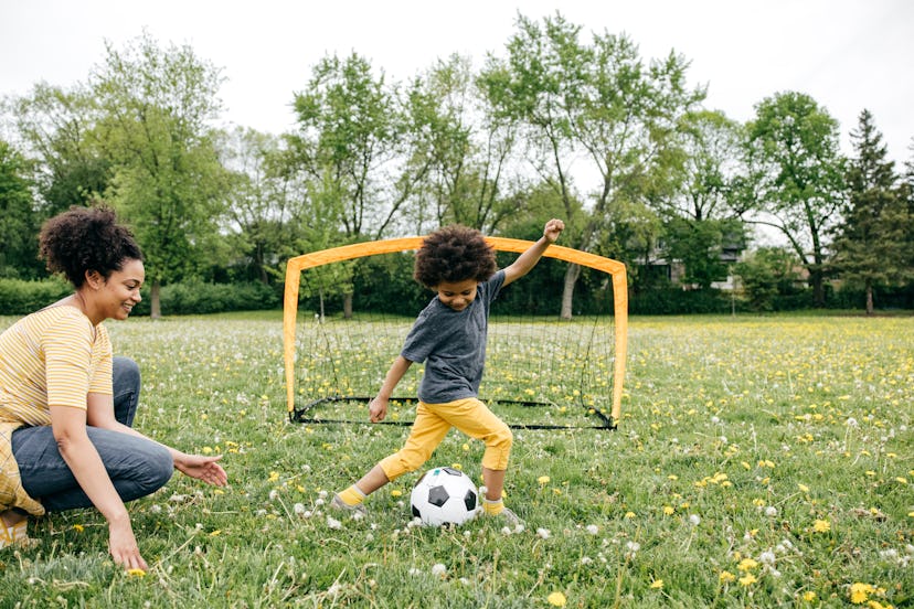 mother and toddler son playing soccer