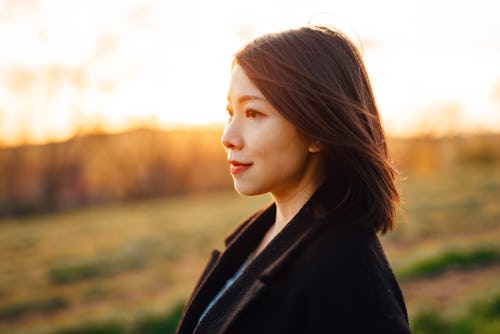 Woman enjoying breeze outdoors at sunset. Gemini, Libra, and Aquarius are the zodiac signs least aff...