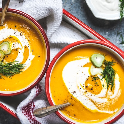 A bright and healthy winter soup, swirled with cashew cream and garnished with dill, fennel root sli...