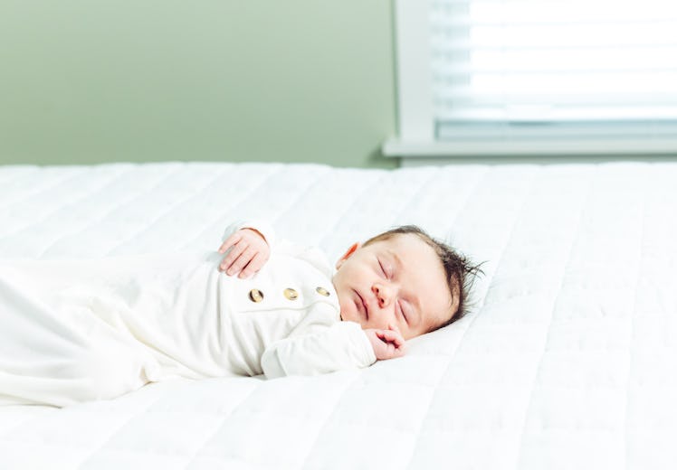 Sleeping newborn in white bed