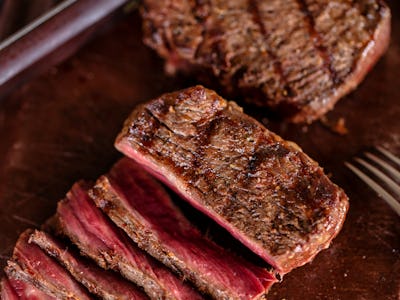 Grilled tasty juicy steak on a cutting board. Medium rare beef steak meat on a cutting board