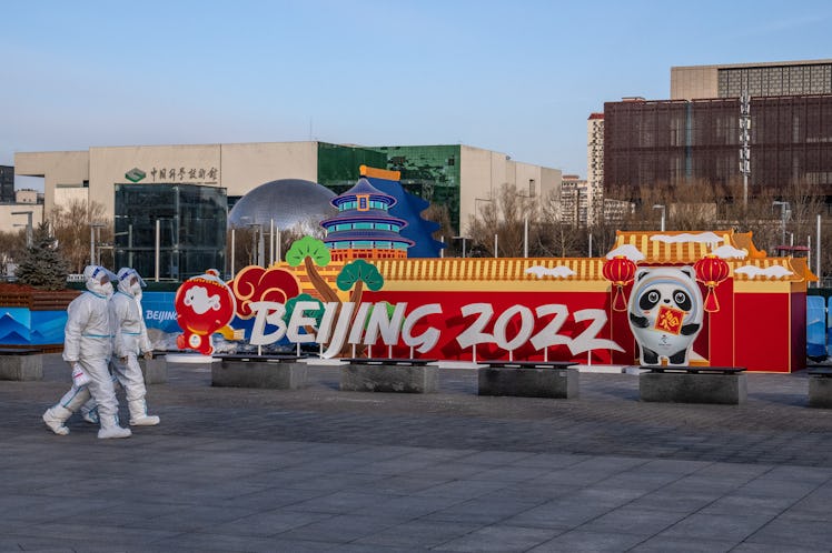 BEIJING, CHINA - JANUARY 26: People in full personal protective kit walk past a Beijing Winter Olymp...
