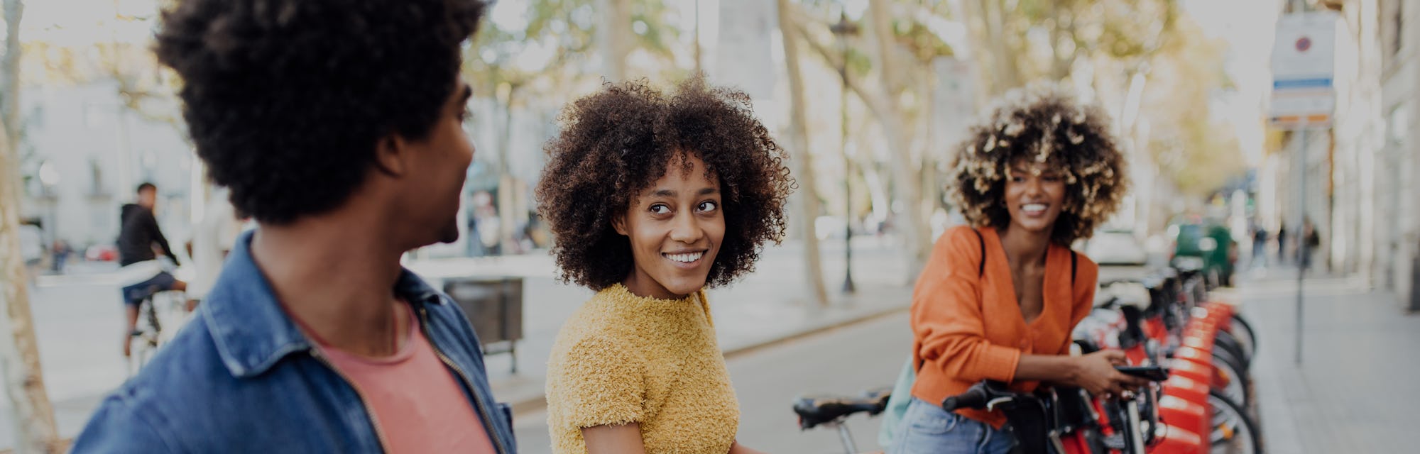 Three young African American friends renting e-bikes to explore Barcelona.