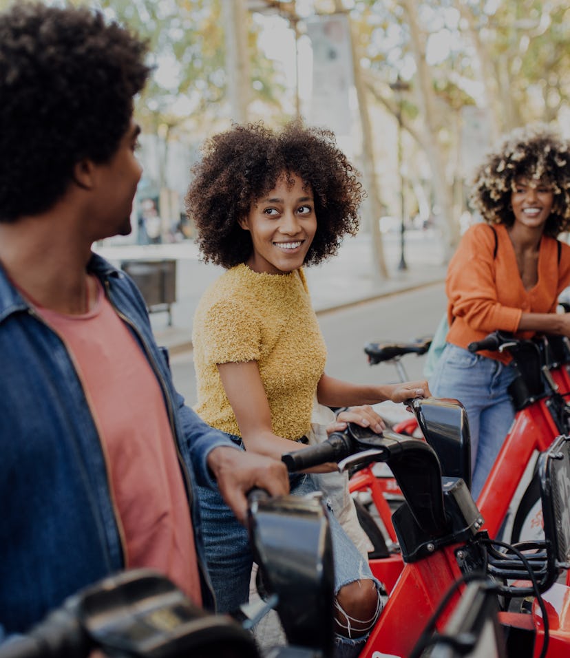 Three young African American friends renting e-bikes to explore Barcelona.