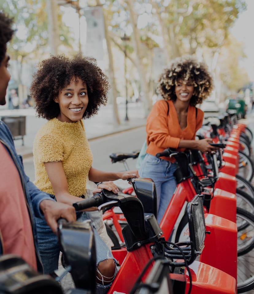 Three young African American friends renting e-bikes to explore Barcelona.