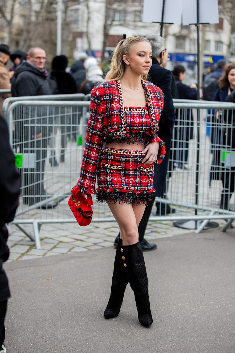 Sydney Sweeney wearing a red checkered Balmain outfit during Paris Fashion Week. 