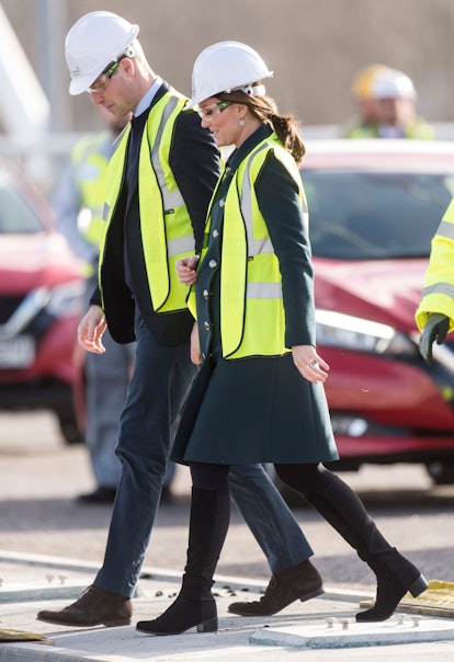 Prince William and Kate Middleton in hard hats and construction vests. 