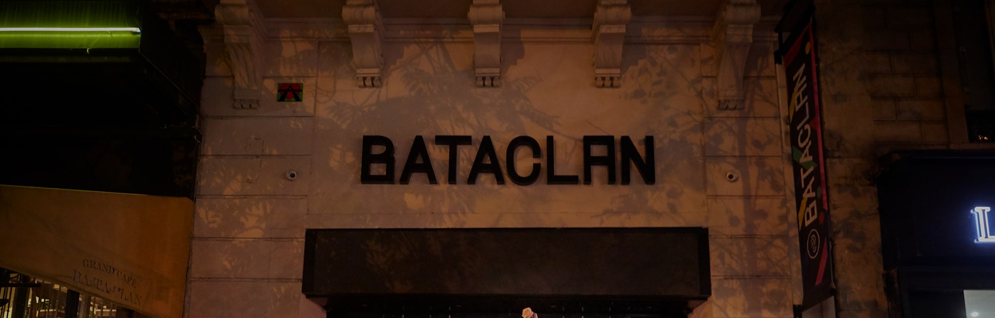 PARIS, FRANCE - NOVEMBER 13: A Parisian holds a flower towards the Bataclan concert hall on the sixt...