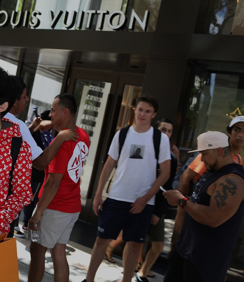 MIAMI, FL - JUNE 30: Mateo Lorente (L) wears his new Supreme shirt as people flock to the Louis Vui...