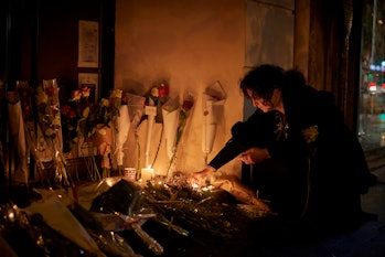 PARIS, FRANCE - NOVEMBER 13: A Parisian lights a candle outside the Bataclan concert hall in memory ...