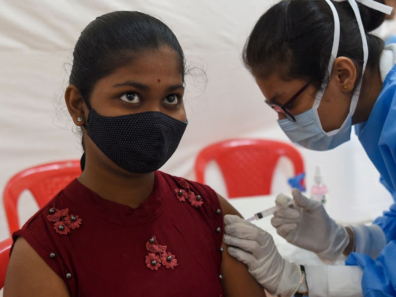 A health worker inoculates a student with a dose of the Covid-19 coronavirus vaccine during a vaccin...