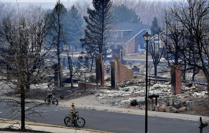 LOUISVILLE, CO - DECEMBER 31: People on bikes survey the damage of burned homes in the Coal Creek Ra...