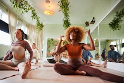 A woman practices yoga in front of a class. Here, astrologers share morning routine ideas for each z...