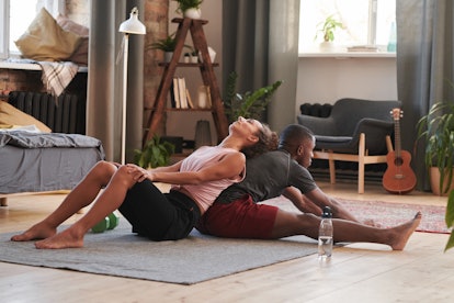 Woman Helping Boyfriend With 2 person yoga poses.
